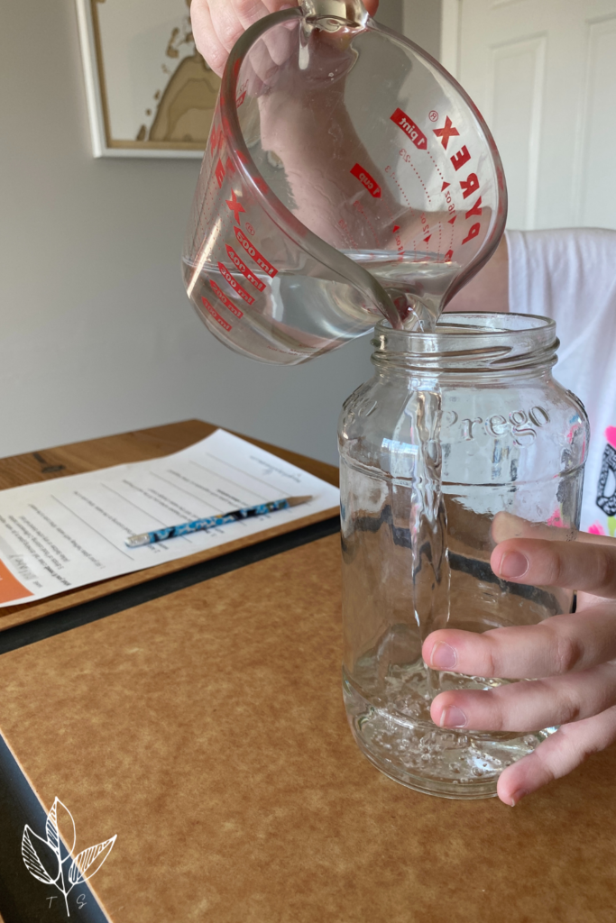 pouring water into a glass jar