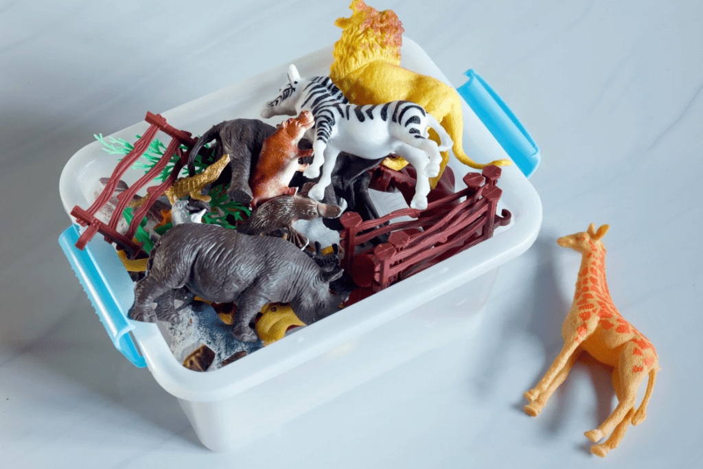 A clear plastic bin filled with plastic animal toys