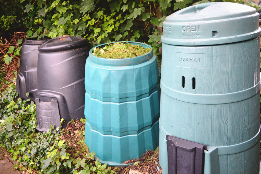 various compost bins arranged in a line in a backyard