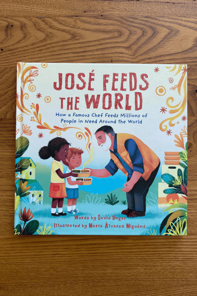 The book, Jose Feeds the World” sits on top of a wooden table.